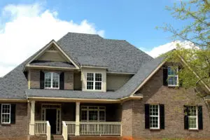 Picture of a brown house with a well maintained roof