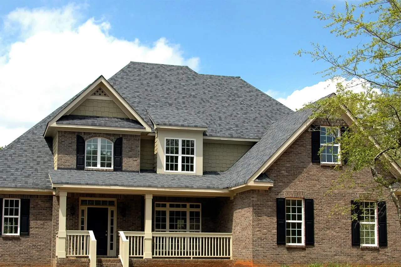 Picture of a brown house with a well maintained roof