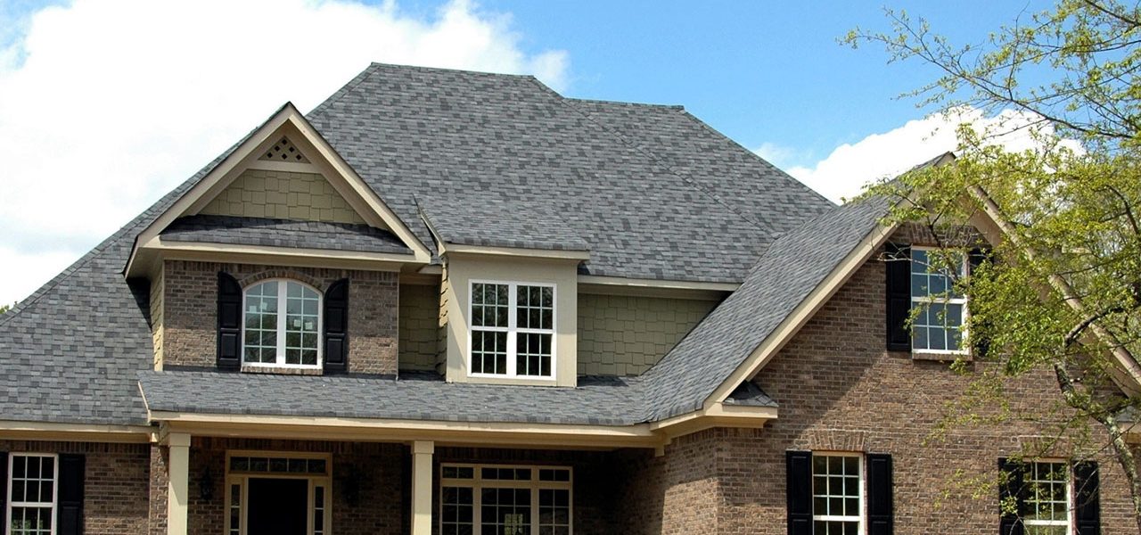 Picture of a brown house with a well maintained roof